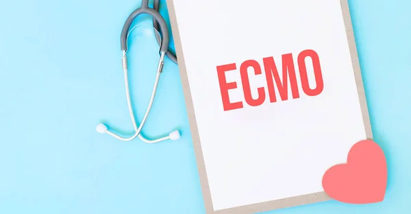 Grey stethoscope and paper plate with a sheet of white paper with text ECMO ight blue backround. Medical concept.