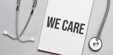 Bej bir arka planda, steteskop ve ilgilendiğimiz beyaz bir not defteri. Tıbbi konsept