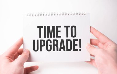 Beyaz kart kâğıdına bir adamın elindeki yazıyı güncelleme zamanı. Beyaz kağıtta siyah harfler. İş konsepti.