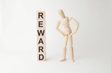 Küp kulesinin yanında tahta manken var. Masada hafif arka planda ödül var.