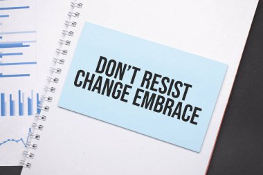 Kağıt tabakta yazı var. Değişime karşı koyma. Sarıl. Diyagram, not defteri ve mavi arkaplan