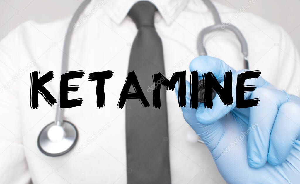 Medicine concept. Doctor writes the word ketamine . Image of a hand holding a marker isolated on a white background.
