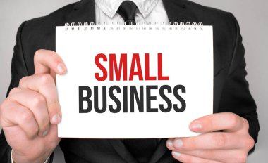 İş adamı elinde küçük bir not defteri tutuyor.