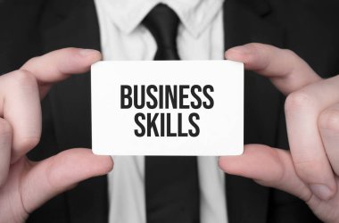 İş adamı elinde metin işi becerileri olan bir kart tutuyor.