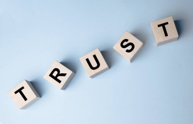 Güven kelimesiyle tahta bloklar. İş ortakları, arkadaşlar ve akrabalar arasındaki güven ilişkileri.