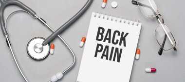 Defterde steteskop, hap ve gözlüğün yanındaki sırt ağrısı var..