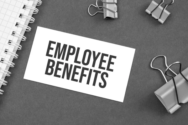 The word Employee Benefits word written on gray background with paper clips. word