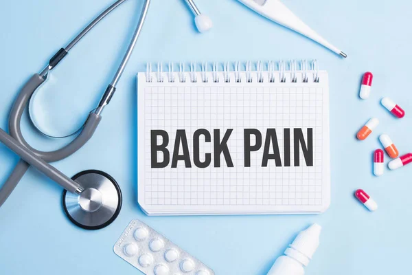Word Back Pain Written White Notepad Blue Background Stethoscope Syringe — Stock Photo, Image