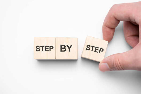 Слово шаг за шагом на деревянных кубиках. Достижение или прогресс в деловой карьере.