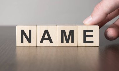 İş stratejisi konsepti. Tahta küp blokta el ve isim.