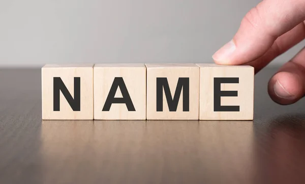 İş stratejisi konsepti. Tahta küp blokta el ve isim.