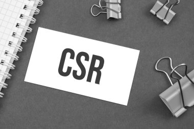 Gri arka planda ataçlarla yazılmış CSR kelimesi. kelime