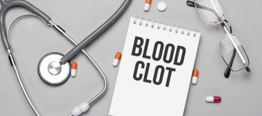 Defterde kan pıhtısı var. Stetoskop, hap ve gözlüğün yanında..