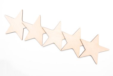 Ahşap masa gri arka planında beş yıldız şeklinde ahşap blok. Blok 5 yıldızları en iyi hizmet mükemmelliği konseptini derecelendirdi. Üstün müşteri kalite memnuniyeti ödülü.