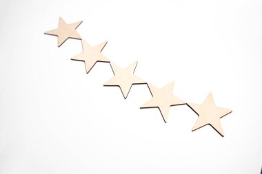 Ahşap masa gri arka planında beş yıldız şeklinde ahşap blok. Blok 5 yıldızları en iyi hizmet mükemmelliği konseptini derecelendirdi. Üstün müşteri kalite memnuniyeti ödülü.