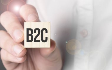 Tahta küpte b2C sözcüğü tutan adam.