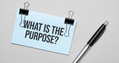 Renkli bir arkaplanda PURPOSE, kalem, ataç içeren bir kartvizitin üst görüntüsü. İş konsepti.