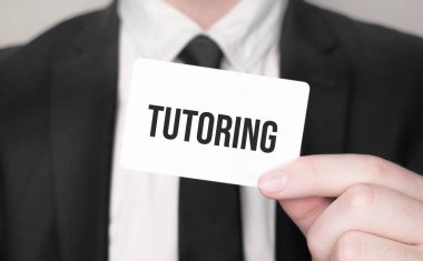 İş adamı elinde yazılı bir kart tutuyor.