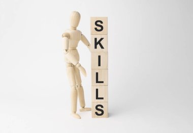 Küp kulesinin yakınındaki tahta manken. Masada, ışık arkaplanına karşı kelime becerileri var.