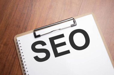 Seo işi, arama motoru optimazyonu, ahşap masadaki beyaz kağıt üzerinde seo metin