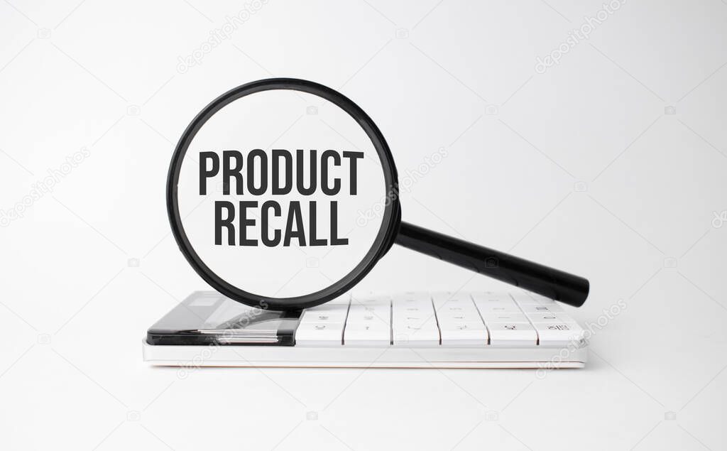 Finance and business concept. On a white background lies a calculator and a magnifying glass with the inscription - Product Recall