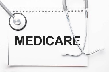 Gri steteskop ve kağıttan bir sayfa beyaz kağıt ve açık mavi arka plan. Tıbbi konsept.