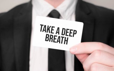 İş adamı elinde yazılı bir kart tutuyor Derin bir nefes al