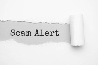 Yırtık kahverengi kağıdın arkasında metin dolandırıcılığı uyarısı görünüyor