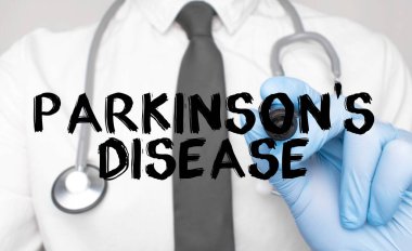 Tıp konsepti. Doktor Parkinson Hastalığı 'nı yazıyor. Beyaz arkaplanda izole edilmiş bir işaret tutan bir elin resmi.