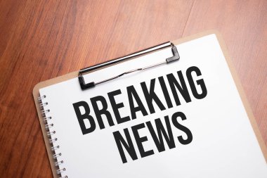 Tahta masadaki beyaz kağıt üzerinde son dakika haberi