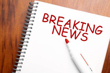 Not defteri, ofis ahşap tablosu ve yukarıdan kırmızı kalemle yazılmış Metin Son Dakika Haberleri blog başlığı veya başlık resmi konsepti. Yıllanmış vintage rengi görünümü.