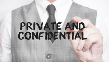 İşadamı not ve iş konsepti ile Özel ve Gizli kelimeler yazıyor.