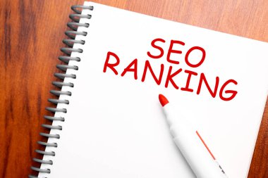 Metin seo sıralaması not defteriyle, ofis ahşap tablosu ve yukarıdan kırmızı kalemle yazılmış blog başlığı veya başlık resmi konsepti. Yıllanmış vintage rengi görünümü.