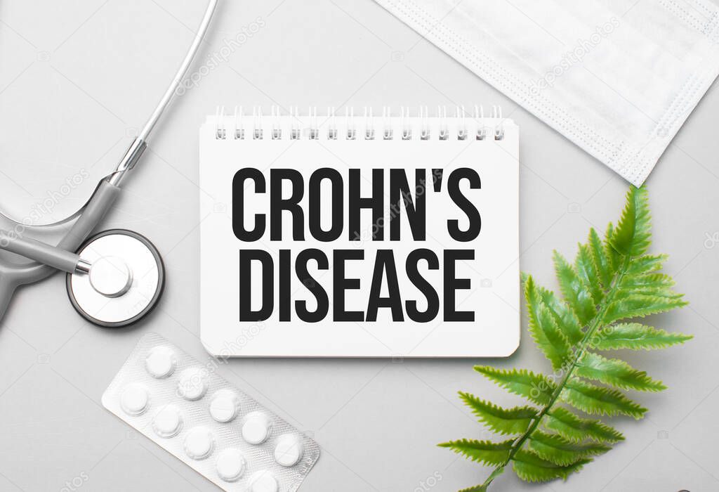 Crohn's disease word on notebook,stethoscope and green plant