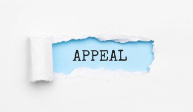 Yırtık sarı kağıdın arkasında görünen APPEAL metni