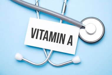 Stetoskop, vitaminli kağıt, tıbbi masada bir metin..