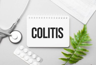 Not defteri, steteskop ve yeşil bitki üzerine kolit kelimesi