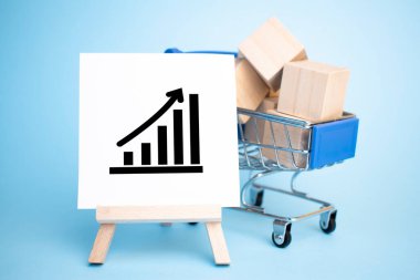 Alışveriş arabası ve satılık tabelalı şövale. Satış konsepti