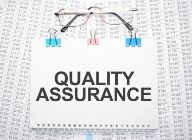 Kalite Güvencesi metni kalem ve gözlüklerle kağıda yazıldı