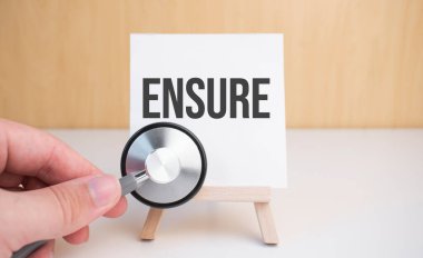 Doktor steteskop ve sehpayı metin ile tutuyor.