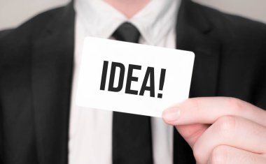 İş adamı elinde metin fikirli bir kart tutuyor.