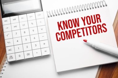 Metni olan not: Hesap makinesi ve kırmızı işaretli COMPETITORSon tahta arkaplanınızı bilin