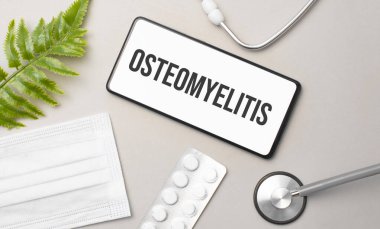 Osteomyelit kelimesi akıllı telefon, steteskop ve yeşil bitki üzerine