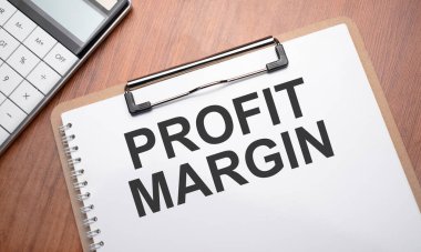 Tahta arkaplan, ataç, kalem ve hesap makinesi ile metin PROFIT MARGIN ile not