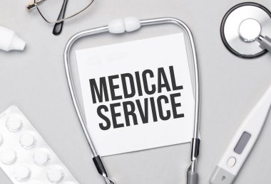 Defterde tıbbi servis steteskopu, haplar ve gözlükler var..