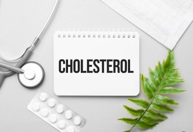 Not defteri, steteskop ve yeşil bitki üzerine kolesterol kelimesi