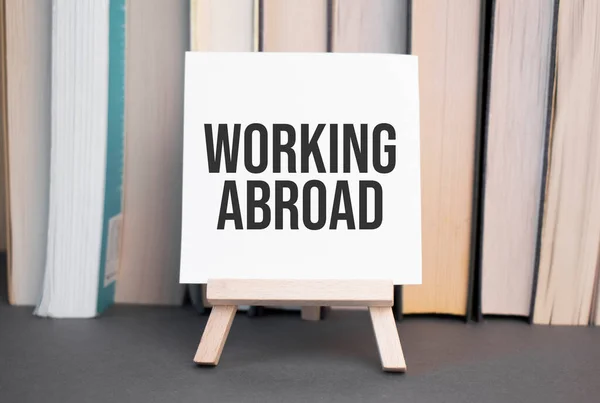 Weiße Karte Mit Text Working Abroad Steht Auf Dem Schreibtisch — Stockfoto