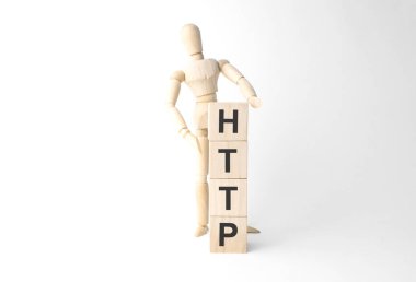 Wooden mannequin near tower of cubes with word http on table against light background