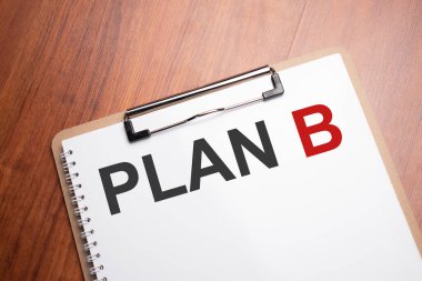PLAN B text on white paper on the wood table