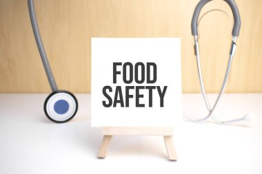 Food Safety sign on small wood board rest on the easel with medical stethoscope